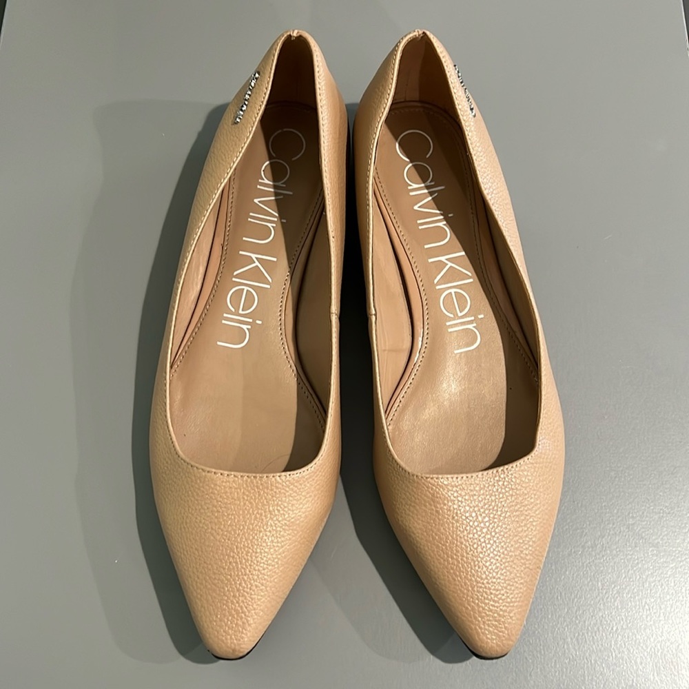 Nude Calvin Klein flats with chrome around the heel